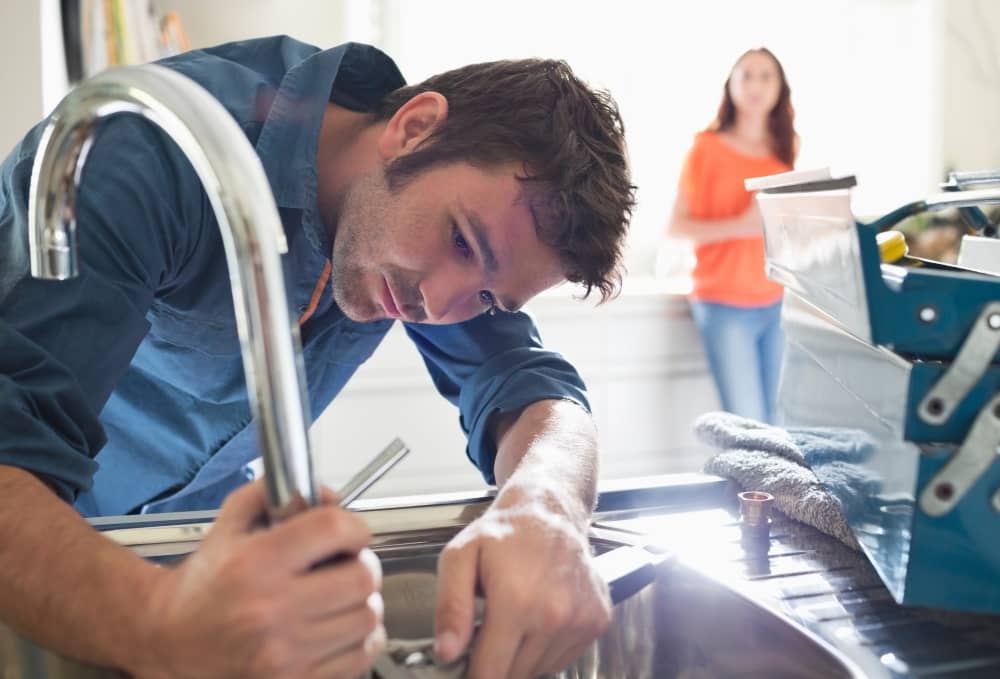 Plumber fixing faucet.